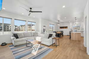 Living room with ceiling fan and light hardwood / wood-style flooring