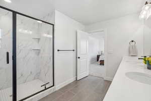 Bathroom with tile patterned floors, a shower with door, and sink