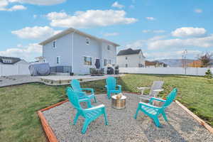 Rear view of property with a lawn and a patio area