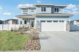 View of front of house featuring a garage and a front yard