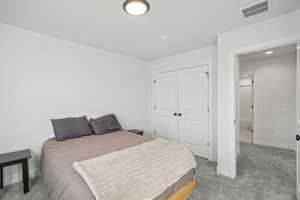 Carpeted bedroom featuring a closet