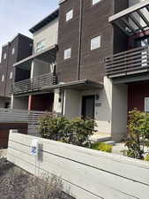 View of front entry area with gardens and cement patio