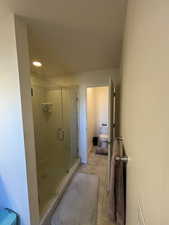 Primary Bathroom featuring tile patterned flooring, toilet, and large walk in shower, private water closet.