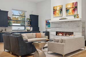 Living room featuring a tile fireplace, light hardwood / wood-style flooring, and sink