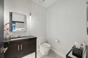 Bathroom featuring tile patterned flooring, vanity, and toilet