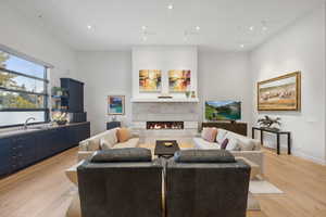 Living room featuring sink, light hardwood / wood-style floors, and a tiled fireplace