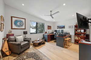 Office featuring ceiling fan, light hardwood / wood-style floors, and vaulted ceiling