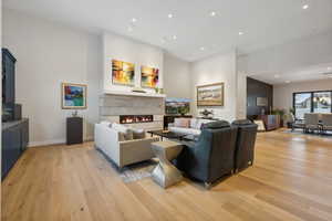 Living room featuring light wood-type flooring and a tiled fireplace