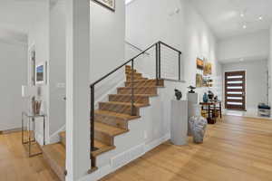 Stairway featuring hardwood / wood-style flooring and a high ceiling