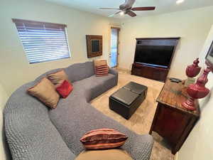 Living room with carpet and ceiling fan