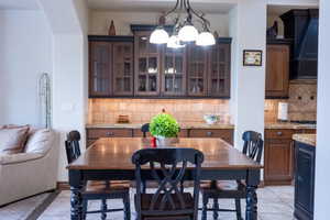 Tiled dining room featuring a chandelier