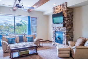 Carpeted living room with ceiling fan and a fireplace