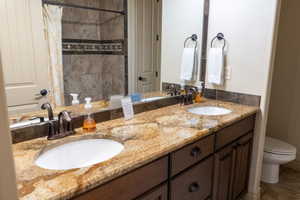 Bathroom featuring tile patterned flooring, vanity, toilet, and a shower with shower curtain