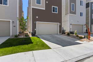 View of front of house with a garage and cooling unit