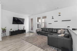 Living room with light hardwood / wood-style floors