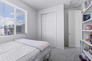 Carpeted bedroom with a closet