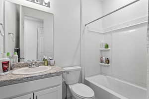 Full bathroom featuring vanity,  shower combination, and toilet