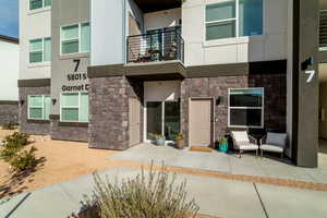 View of exterior entry with a balcony and a patio area