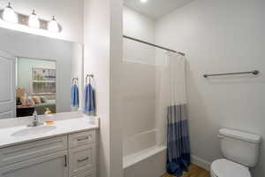 Full bathroom featuring shower / tub combo, vanity, hardwood / wood-style flooring, and toilet