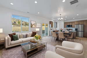 Living room featuring a chandelier, a healthy amount of sunlight, and wood-type flooring