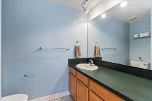 Bathroom with tile patterned floors, vanity, and toilet