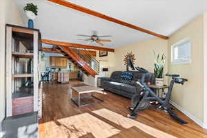 Living room with beam ceiling, ceiling fan, and dark wood-type flooring