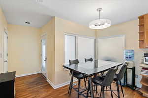 Dining area with dark hardwood / wood-style floors