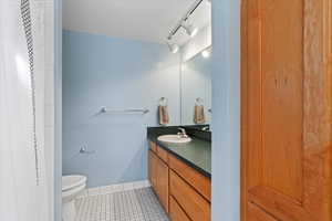 Bathroom with tile patterned floors, vanity, and toilet