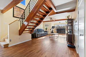 Living room featuring ceiling fan, beam ceiling, and wood-type flooring