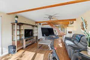 Living room with hardwood / wood-style floors, ceiling fan, and beam ceiling