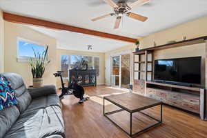 Living room featuring beam ceiling, hardwood / wood-style flooring, and ceiling fan