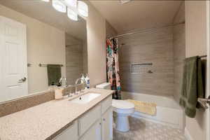 Full bathroom featuring vanity, toilet, and shower / bath combo with shower curtain