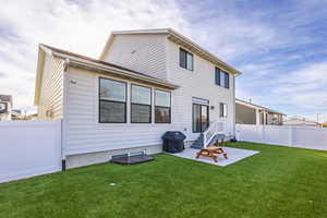 Back of house with a patio area and a lawn