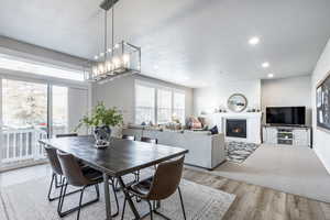 Dining space with light wood-type flooring and an inviting chandelier