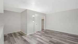 Empty room with light hardwood / wood-style floors