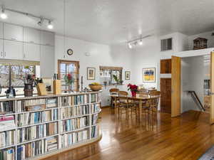 Dining room with hardwood / wood-style floors, rail lighting, and a textured ceiling