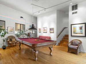 Rec room with light wood-type flooring, track lighting, and pool table (included)...in between the main floor and second floor.