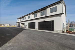 View of front facade with a garage and cooling unit