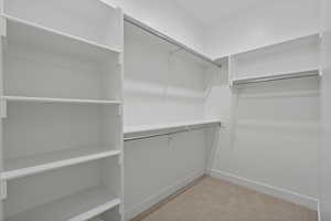 Walk in closet with light carpet