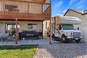 View of property exterior with a patio, a wooden deck, and a hot tub