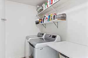 Washroom featuring hardwood / wood-style floors and washer and clothes dryer