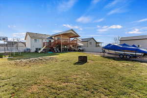 View of yard featuring a deck and a trampoline