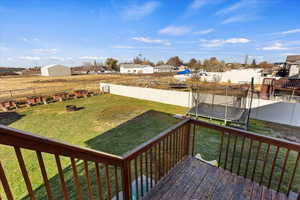 View of yard featuring a trampoline and a deck