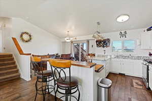 Kitchen featuring stainless steel range, dark hardwood / wood-style flooring, white cabinetry, and plenty of natural light