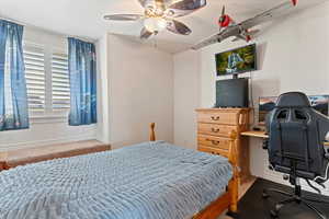 Carpeted bedroom featuring ceiling fan