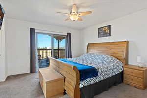 Carpeted bedroom with access to exterior and ceiling fan