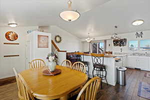 Dining area with lofted ceiling, plenty of natural light, dark wood-type flooring, and sink