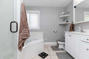 Full bathroom featuring tile patterned floors, plenty of natural light, vanity, and toilet