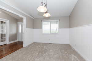 Spare room with crown molding, light hardwood / wood-style floors, and lofted ceiling