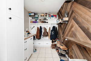 Mudroom featuring sink and light tile patterned flooring